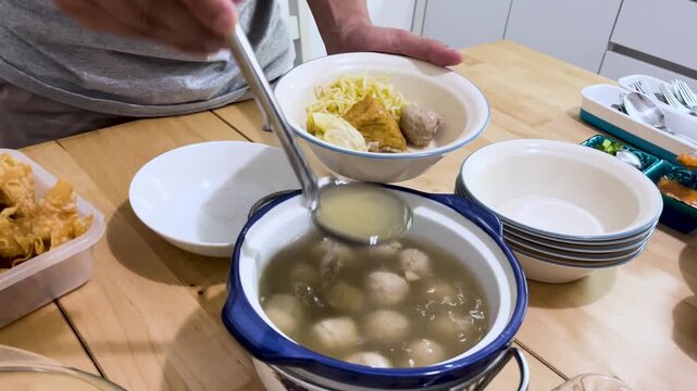 Serving Hot Meatball Soup with Noodles in Home Kitchen Dining Scene
