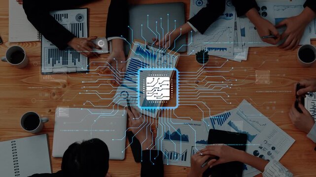 Aerial view of a collaborative workspace featuring business professionals analyzing charts and discussing strategies over a table with technology elements and data visualization. Raster