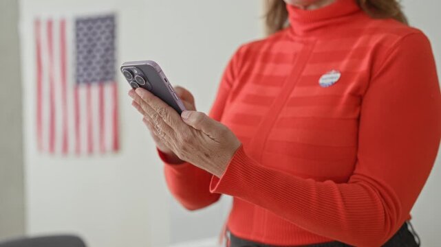 Woman holding smartphone with i voted sticker and fingers tapping screen at polling station; patriotic civic duty.