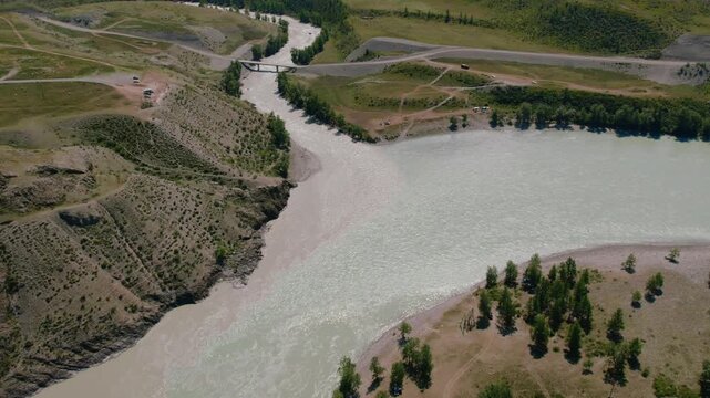 Drone footage of the confluence of the Chuya and Katun rivers, with bridge, gravel banks and steppe landscape near Inya, Altai Republic, Russia
