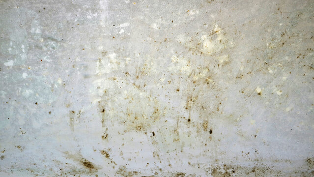 Dirty, weathered concrete wall texture with stains, scratches, and speckled marks in light gray and beige tones