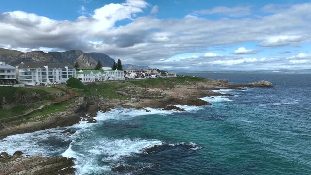 Approaching aerial view with seaside cliffs in Hermanus, South Africa.