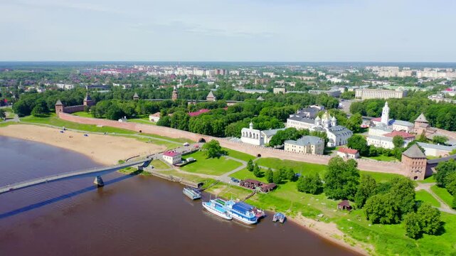 Veliky Novgorod, Russia. Novgorod Kremlin (Detinets) with golden-domed cathedrals and 15th-century stone walls, Drone footage over the Volkhov River on a bright summer day.. Drone footage