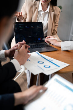 Business Team Analyzing Financial Data on Laptop and Documents