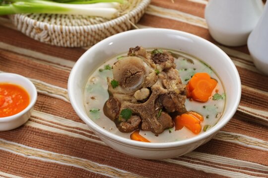 Close up of oxtail soup or sop Buntut showing tender meat and vegetables, highlighting texture and rich traditional flavor.