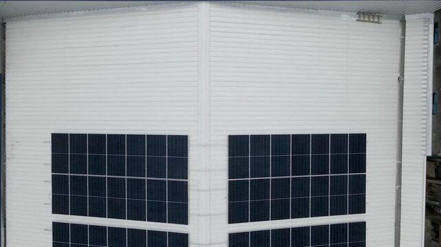 Solar panels installed on industrial warehouse roof generating renewable energy