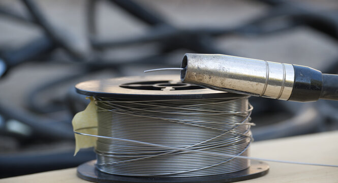 Welding wire spool and MIG gun nozzle ready for metal fabrication work