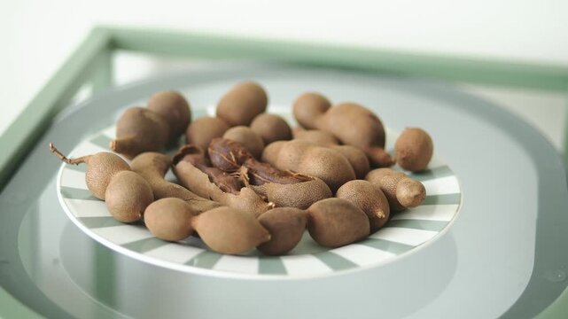 Eating tamarind fruit from a plate