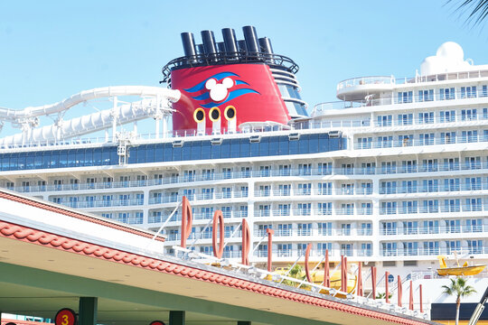 A Port Canaveral cruise port sign with a Disney Cruise Line ship in the background in Port Canaveral, Florida on December 27, 2025.