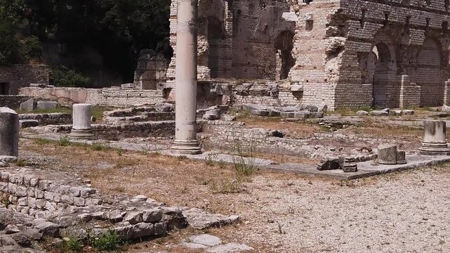Wide angle footage of Ancient Messene ruins in Peloponnese, Greece, featuring weathered stone columns, crumbling Roman walls, sunlit architecture, and detailed archaeological textures. 200 characters.