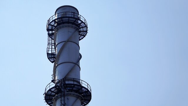 Industrial Chimney Stack With Spiral Staircase Against Clear Sky