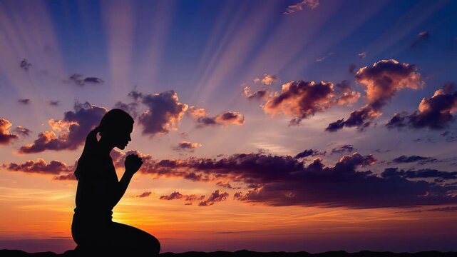 Silhouette of Woman Praying at Sunset with Sky and Clouds.