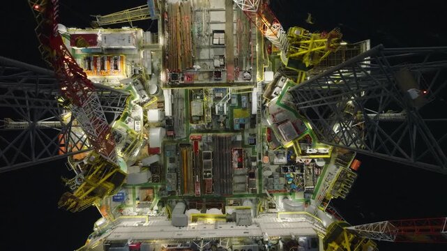 Aerial top view of offshore jack up rig and offshore platform during sunset for oil and gas exploration and production. 