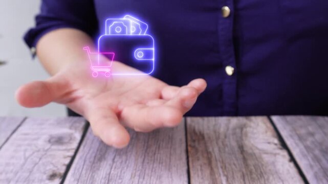 Money management for daily purchases. Calculation of total shopping costs. Close-up of a woman's hand on a table holding a virtual wallet with a shopping cart icon.