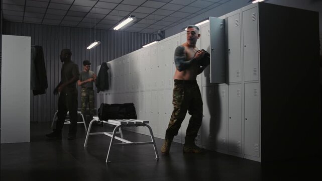 Three Athletic Soldiers in Uniforms in Locker Room, Chat Casually, Dressing and Preparing Gear For Mission or Combat Training on Base. Concept of Team Interaction, Military Service and Preparation.