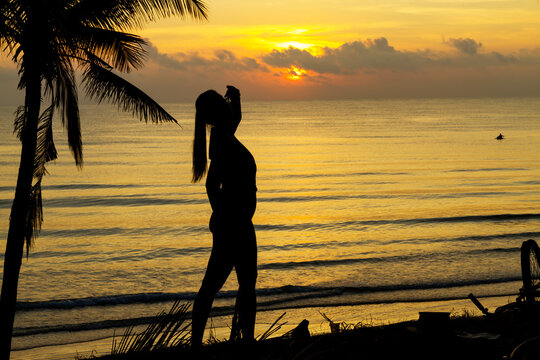 Sunrise with silhouette woman and coconut