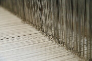 Macro view of warp threads and heddle threads on a weaving loom © Yucel