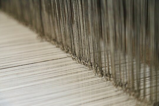 Macro view of warp threads and heddle threads on a weaving loom
