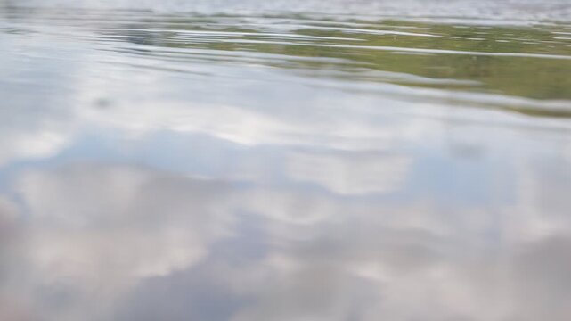 Gentle Ripples on a Puddle Reflecting the Sky
