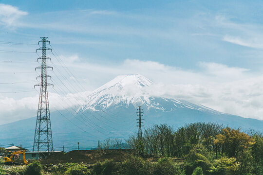 Mount Fuji framed by tall electric pylons and power lines in Yamanashi Japan
