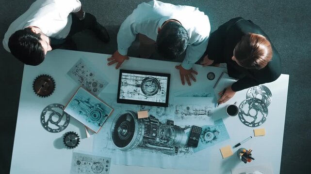 Top down view of engineer working together while shaking hands or making a contract. Aerial view of designer or diverse technicians brainstorming while looking at electronic generator. Alimentation.