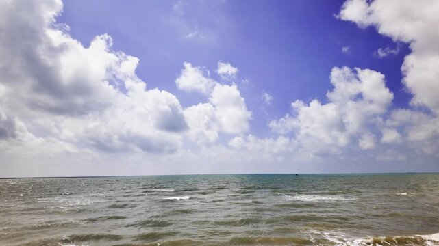 Bai Tam Nong Noc beach is shown in Vung Tau, Vietnam. Waves roll onto the sandy shore while people relax and enjoy the beach atmosphere throughout the day.