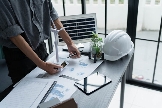 Electrical engineer working with wind turbine model sustainable energy concept