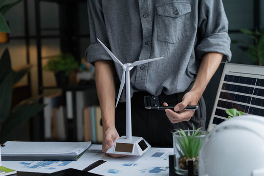 Electrical engineer working with wind turbine model sustainable energy concept