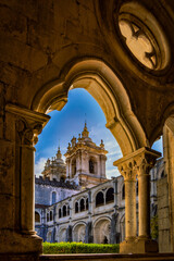 Obraz premium Mosteiro de Santa Maria de Alcobaça cloister framed by Gothic arches in Alcobaça, Portugal, a UNESCO World Heritage monastery.