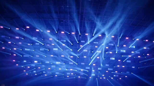 Concert lighting rig viewed from below with dramatic blue beams