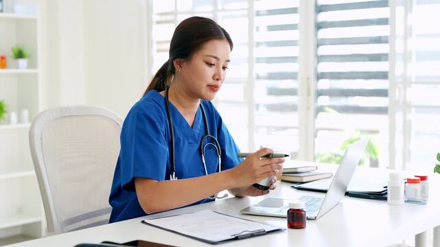 Confident asian doctor talking on video call by looking at camera from hospital with patients. concept of online counseling, medical advice and consultation.