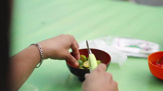 Street Vendor Cutting Calamansi (Lemonsito) for BBQ Sauce Preparation 