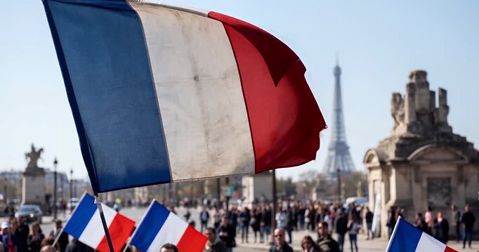 French flag waving proudly in Paris with the iconic Eiffel Tower in the background, amidst a crowd of people.