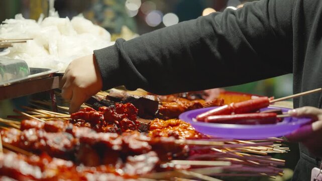 Customers Selecting BBQ Skewers at Street Food Stall in Local Market Philippines