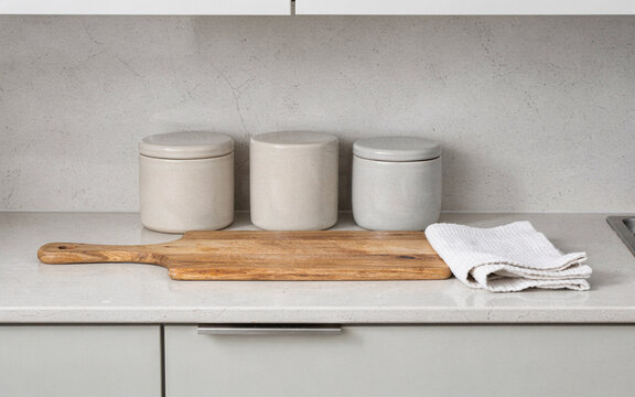 organized kitchen counter with plain canisters cutting board and folde