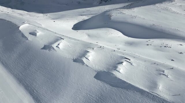 Aerial panoramic view of a freestyle snow park in the mountains.