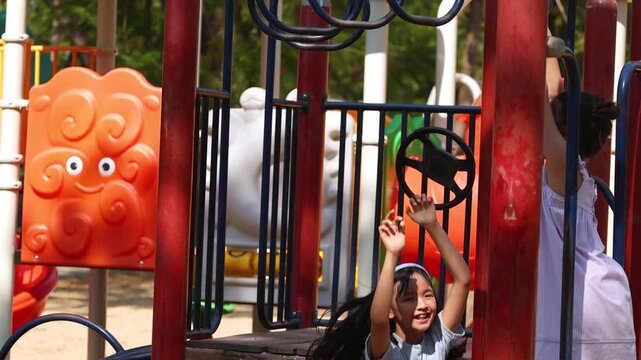 Young Thai Girl Playing on Monkey Bars at Lumpini Park Playground