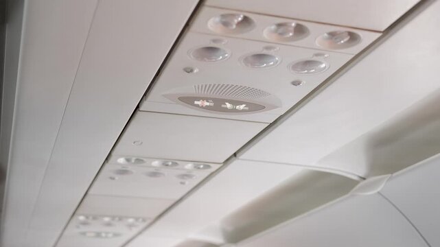look up view to overhead seatbelt and no smoking sign in aircraft airplane cabin while airplane climbing flying.aircraft cabin overhead safety sign,Fasten Seatbelt Sign on Commerical Aircraft