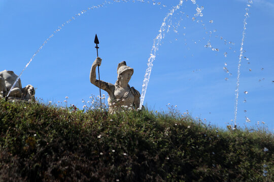 Statua monumentale della dea Minerva o Roma con lancia svettante sopra una siepe nei giardini di Villa d'Este a Tivoli con giochi e spruzzi d'acqua in primo piano