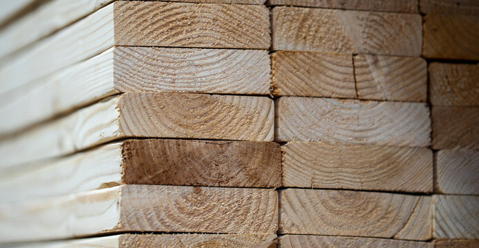 Stacked wood boards, lumber timber texture. Timber planks. Raw lumber boards, construction background. Wooden timber planks stacked. Natural wood timber pattern.