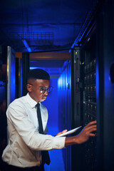 Fototapeta premium Technician, man or tablet with server room inspection for rack maintenance, system backup or solution. IT engineer, black person or tech in dark data center for diagnostics, hardware check or upgrade