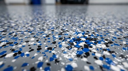 Fototapeta premium Gray epoxy coating mixed with blue, black, and white plastic chips.