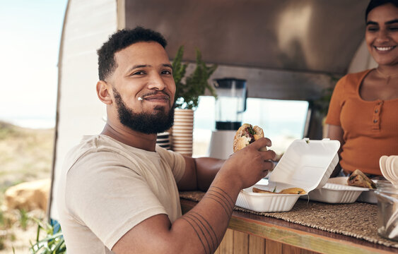 Eating, happy and portrait of man at food truck with meal, small business or weekend at outdoor cafe. Lunch, smile and male person with burger at vendor of mobile restaurant for hospitality service.