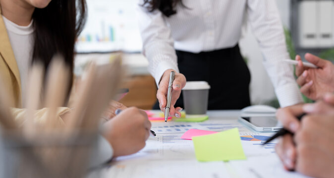 Business people team analyzing financial charts in office meeting.