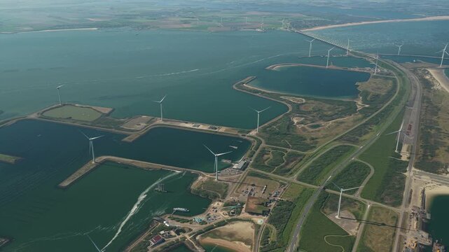 Aerial view of the Eastern Scheldt Storm Surge Barrier with wind turbines and coastal infrastructure in Vrouwenpolder, Zeeland, Netherlands.