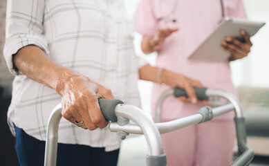 Obraz premium Hands, walker and nurse with tablet at retirement home with guide, steps and balance for recovery. Elderly person with disability, caregiver and tech with walking frame, support and app at house