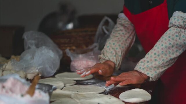 Hands preparing fresh flatbread dough in traditional kitchen