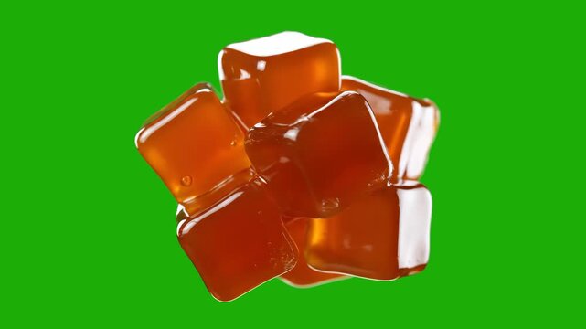 A clustered stack of translucent orange gelatin or candy jelly cubes jiggles and spins against a bright green screen background. This isolated 3D asset is ideal for food and confectionery commercials,