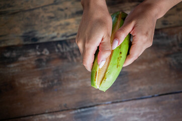 people peeling green plantain for patacones on rustic wooden table © Stock Latino