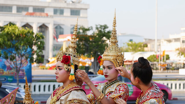 Thai Traditional Dancers Adjusting Ornate Golden Chada Headdresses in Bangkok City